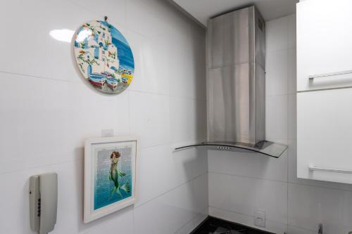 un baño con una foto y un reloj en la pared en Studio Catete, en Río de Janeiro