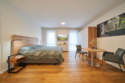 1 dormitorio con 1 cama, mesa y sillas en Parkblick Bad Driburg, en Bad Driburg