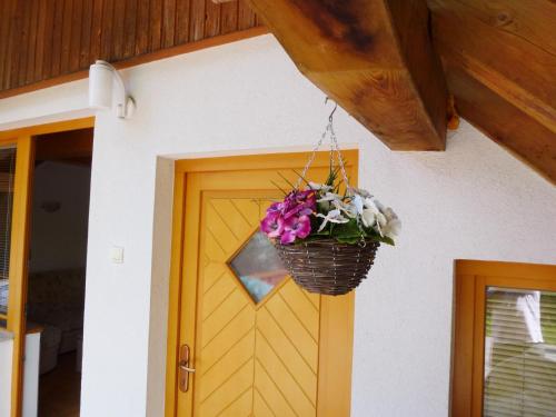 una puerta con una cesta de flores colgando de ella en Apartment Jalps 3 in beautiful Bohinjska Bistrica en Bohinj