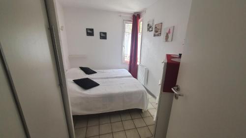 une petite chambre avec un lit et un miroir dans l'établissement JOLI T2 DANS UN ECRIN DE VERDURE n 2, à Digne-Les-Bains