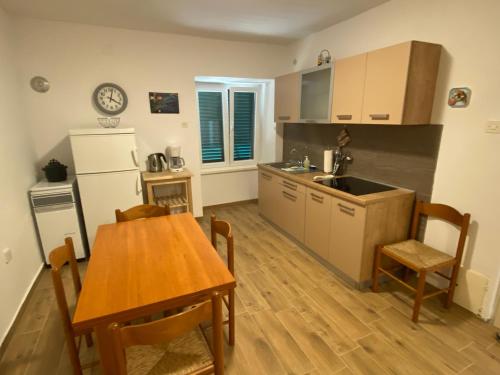 a kitchen with a wooden table and a table and a dining room at Holiday Home Olea in Punat