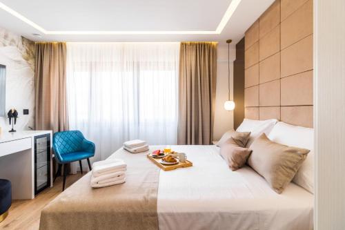 a hotel room with a bed with a tray of food on it at Sky Residence Split in Split
