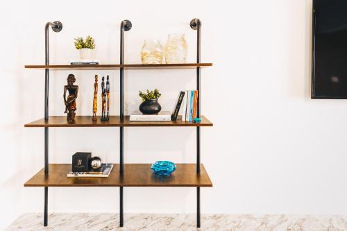 a shelf with books and other items on it at LOFTS by Elegant Hospitality in Cairo