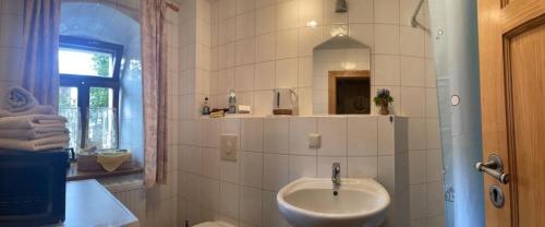 a white bathroom with a sink and a mirror at Zelte individuell auf der Obstwiese in Dippoldiswalde