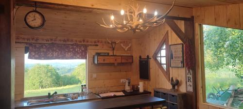 cocina con fregadero, reloj y ventana en Domaine le lanis "cabane de Pauline" en Saint-Girons