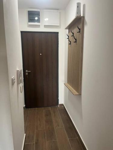a hallway with a brown door and a wooden floor at Apartment SIA in Voždovac