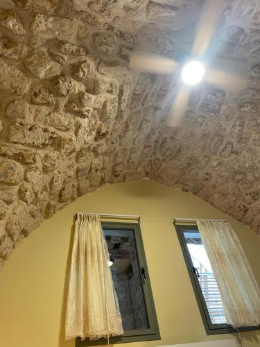 a room with a stone ceiling with a window and a mirror at Hebi house in ‘Akko