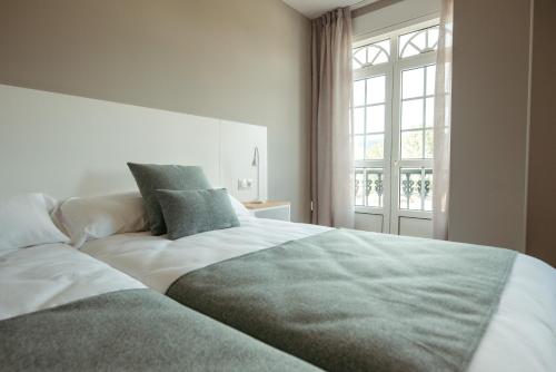a bedroom with a large bed and a window at LAR DA REVOLTA in Cedeira
