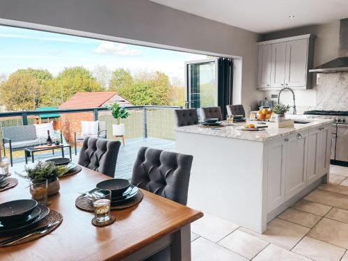 a kitchen and dining room with a large window at Beechwood Park by Solace Stays in Newport