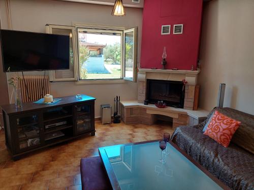 a living room with a couch and a flat screen tv at BIRD S SONG in Lixouri