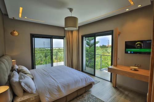 ein Schlafzimmer mit einem Bett und einem großen Fenster in der Unterkunft Riad Bella Montana in Fès