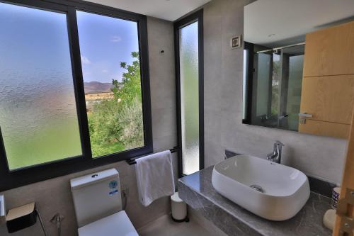 ein Badezimmer mit einem Waschbecken und zwei Fenstern in der Unterkunft Riad Bella Montana in Fès
