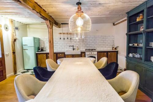 eine Küche mit einem langen Tisch und Stühlen in der Unterkunft Casa dintre dealuri in Rozavlea