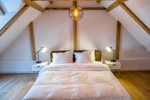 a bedroom with a white bed with two lamps at Casa dintre dealuri in Rozavlea