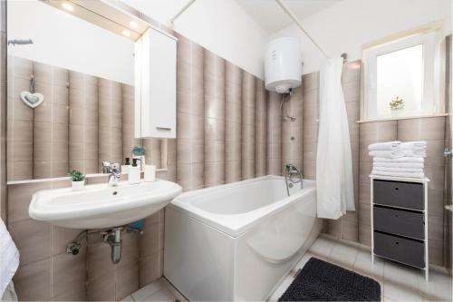 a bathroom with a sink and a toilet and a tub at Apartments Mirjana Mljet in Prožura