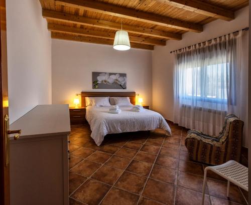 sypialnia z łóżkiem i dużym oknem w obiekcie Las Casas de Pecheye w mieście Bocigas
