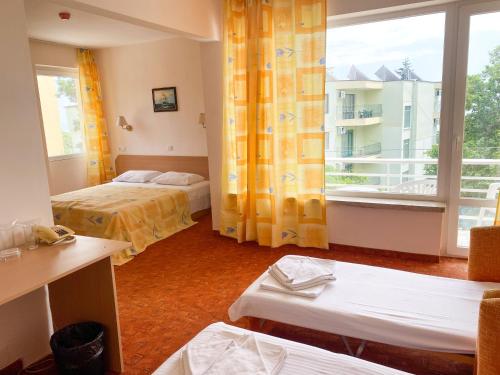 a room with two beds and a large window at Vezhen Hotel - Free Parking in Golden Sands