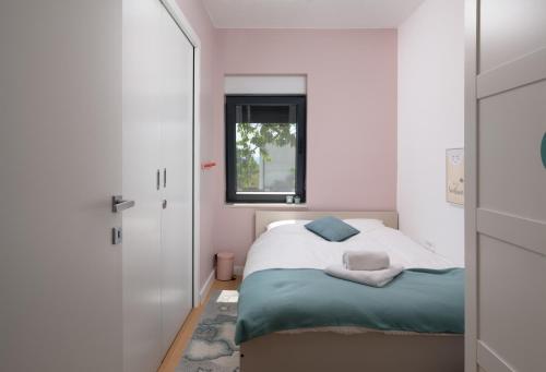 a small bedroom with a bed and a window at Villa Voyage in Zadar