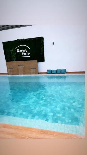 a large swimming pool with blue water in a room at Nandy's home in Odza II