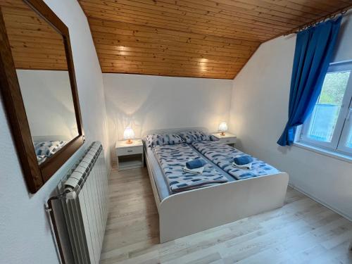 a bedroom with a large bed and a mirror at Apartmaji in Sobe Cuder in Soča