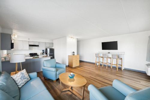 a living room with a blue couch and a table at Sugar Sands Beachfront Hotel, a By The Sea Resort in Panama City Beach