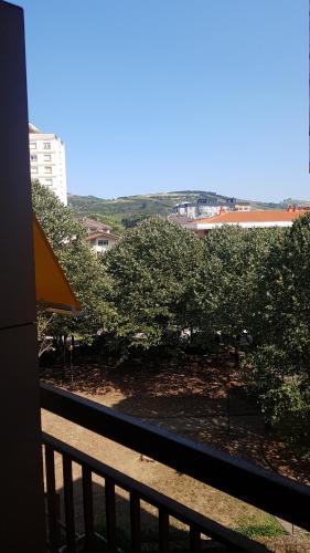 a balcony with a view of trees and buildings at Apartamento Pilartxo Zarautz in Zarautz