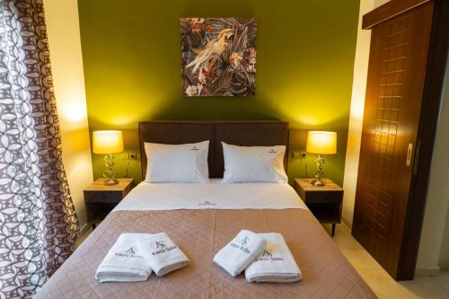 ein Schlafzimmer mit einem Bett mit zwei Handtüchern darauf in der Unterkunft Anesis Suites in Volos