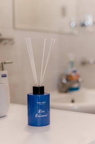 a blue container with white sticks in it on a counter at Hermes Modern Apartment in Alexandroupoli
