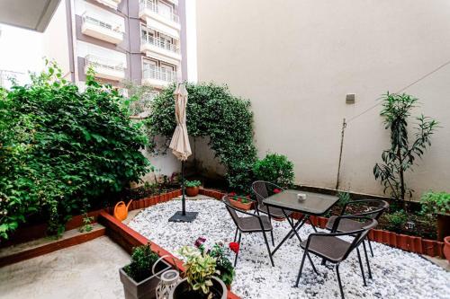 une terrasse avec une table, des chaises et un parasol dans l'établissement Hermes Modern Apartment, à Alexandroúpolis