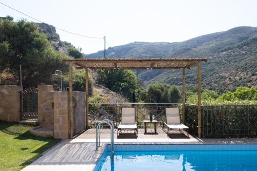 una piscina con 2 sillas y un cenador en Patriko Villa, en Kissamos