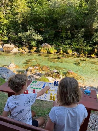 two children sitting at a picnic table playing chess at Apartmaji in Sobe Cuder in Soča
