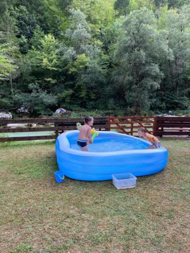 a young boy playing in a blue inflatablelatable pool at Apartmaji in Sobe Cuder in Soča