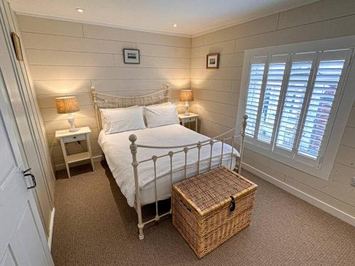 考斯的住宿－Stylish 3BR Cowes Cottage Close To The Waterfront，卧室配有白色的床、两张桌子和窗户。