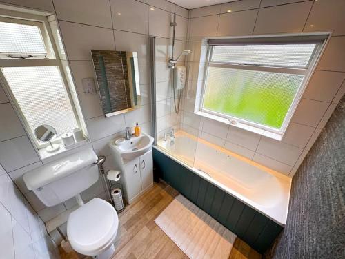 ein Badezimmer mit Badewanne, Toilette und Waschbecken in der Unterkunft Stylish 3BR Cowes Cottage Close To The Waterfront in Cowes