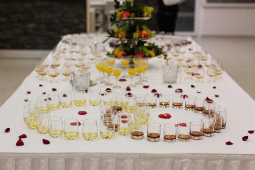 a table with glasses of wine and roses on it at Hotel Slaven in Selce