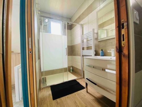 a bathroom with a glass shower and a sink at L’escale Abbevilloise by H2C in Abbeville
