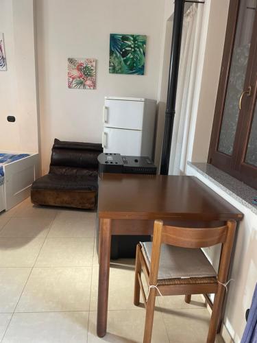 a kitchen with a table and a chair and a refrigerator at Court Inn in Galliate
