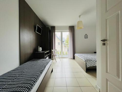 a bedroom with two beds and a window at Villa Cicha in Karwia
