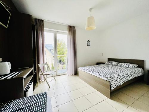 a bedroom with a bed and a window at Villa Cicha in Karwia
