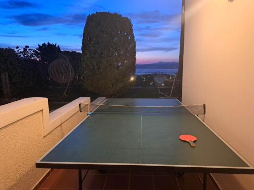 a ping pong table in a balcony with a table at Amazing Villa with private pool in Markópoulon Oropoú