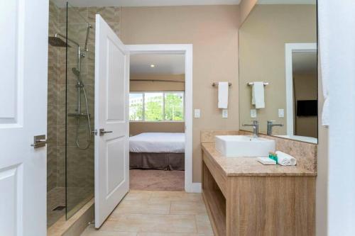 a bathroom with a sink and a glass shower at Modern and Luxury 4 suites close to Disney 7544 in Orlando