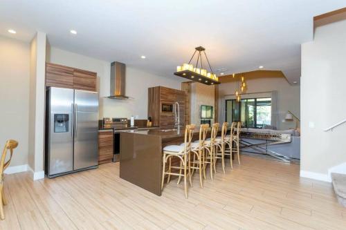 a kitchen with a stainless steel refrigerator and wooden cabinets at Modern and Luxury 4 suites close to Disney 7544 in Orlando