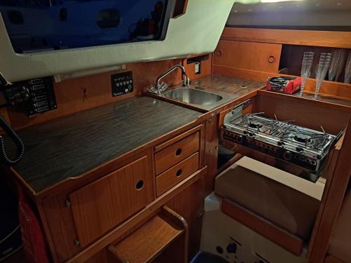 una pequeña cocina con fregadero y fregadero en Unique boat, en Höganäs