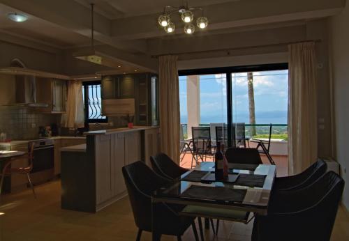 uma cozinha e sala de estar com uma mesa e vista para o oceano em Amazing Villa with private pool em Markópoulon Oropoú