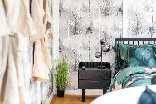 a bedroom with a bed and a wallpaper with trees at The Pod at Avonwood House 