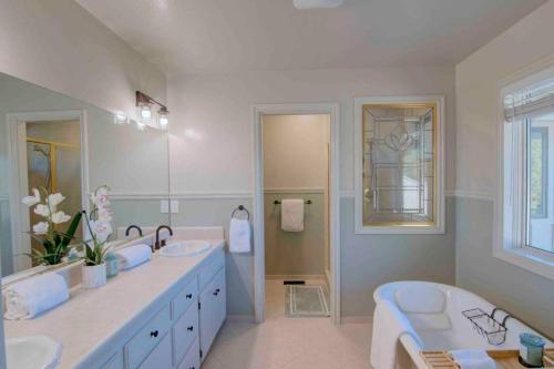 Baño blanco con 2 lavabos y bañera en Spacious home with pool, bar, game room, parking, on 5 private acres., en Oroville