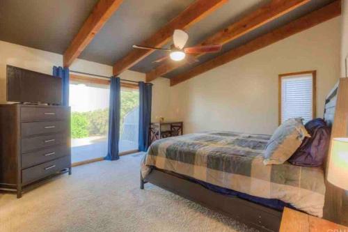 1 dormitorio con 1 cama y vestidor con TV en Spacious home with pool, bar, game room, parking, on 5 private acres., en Oroville