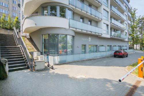 um edifício com um carro estacionado em frente em Comfy Apartment Kapitańska & Parking & Balcony by Renters em Gdynia
