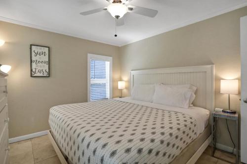 um quarto com uma cama com um edredão branco e uma janela em Casa Del Sol A em Bradenton Beach
