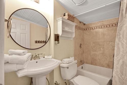 a bathroom with a sink and a toilet and a mirror at Casa Del Sol A in Bradenton Beach